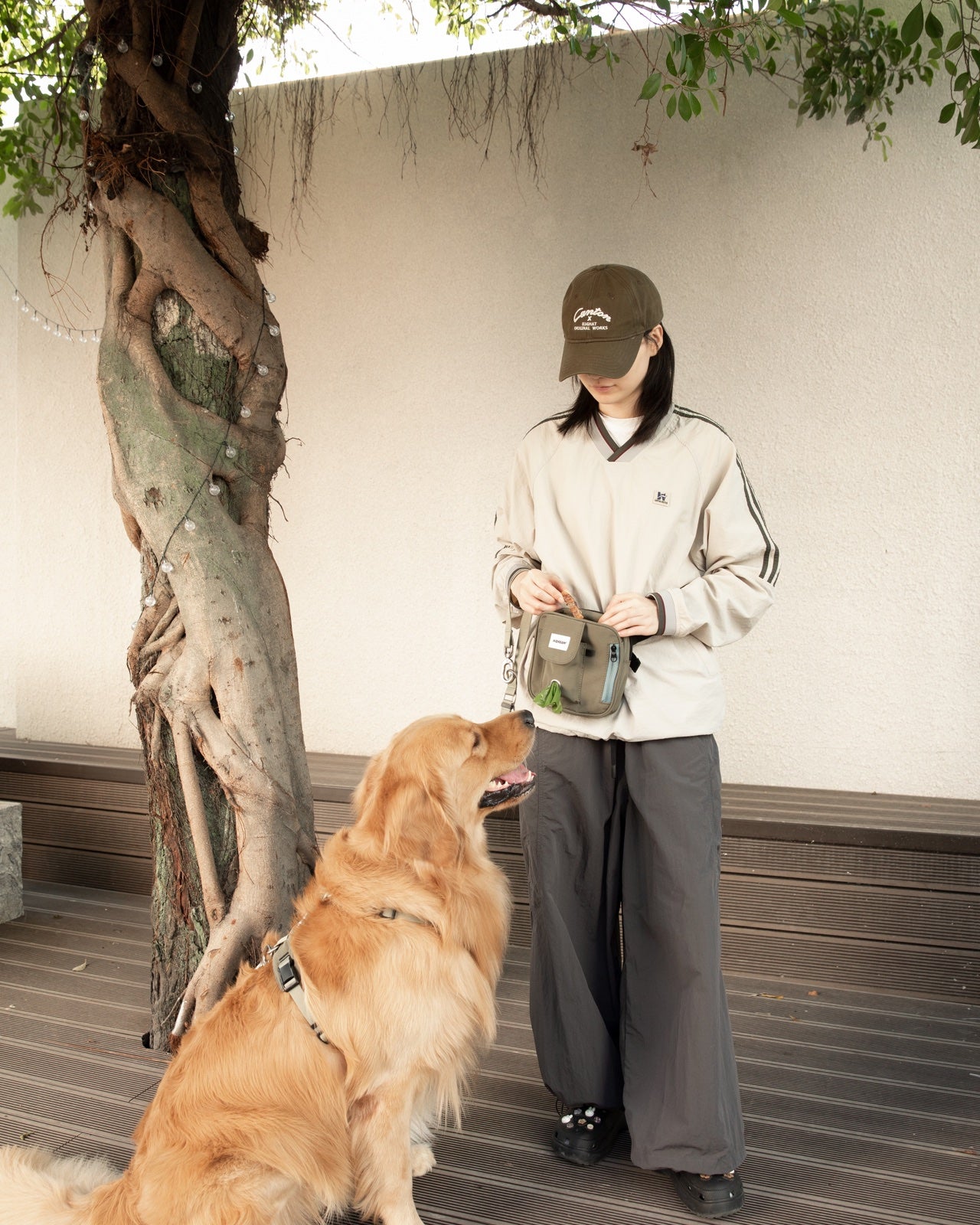 A pet parent organising walk essentials beside a golden retriever